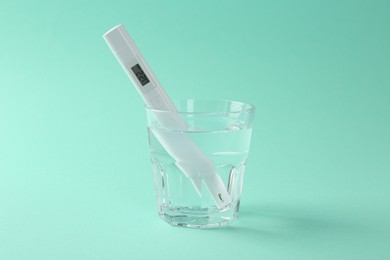 Photo of Nitrate tester in glass of water on turquoise background