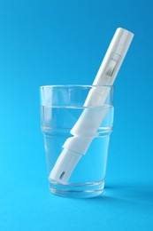 Photo of Nitrate tester in glass of water on light blue background