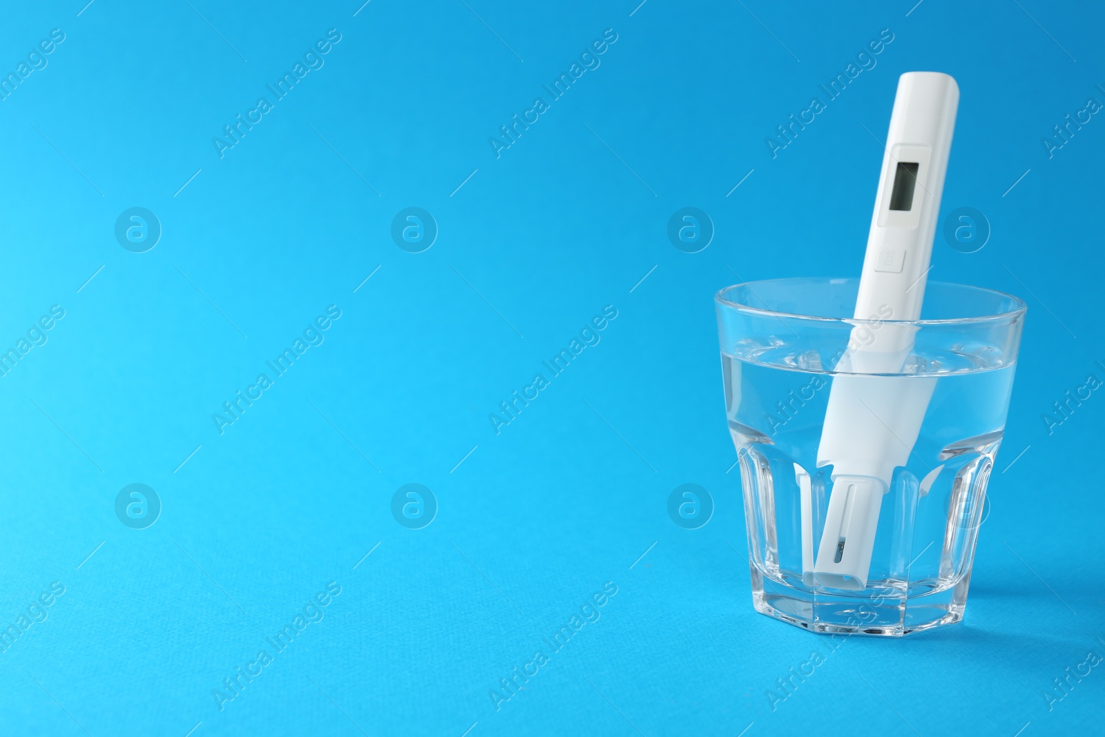 Nitrate tester in glass of water on light blue background, space for text Photo of Nitrate tester in glass of water on light blue background, space for text