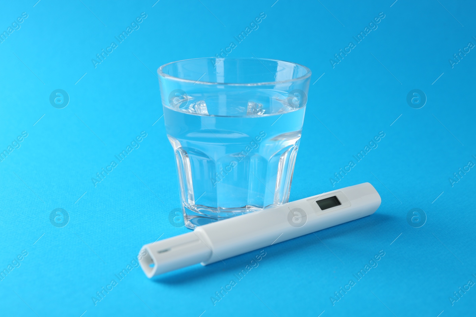 Nitrate tester and glass of water on light blue background, closeup Photo of Nitrate tester and glass of water on light blue background, closeup