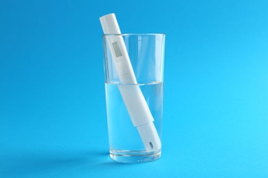 Photo of Nitrate tester in glass of water on light blue background
