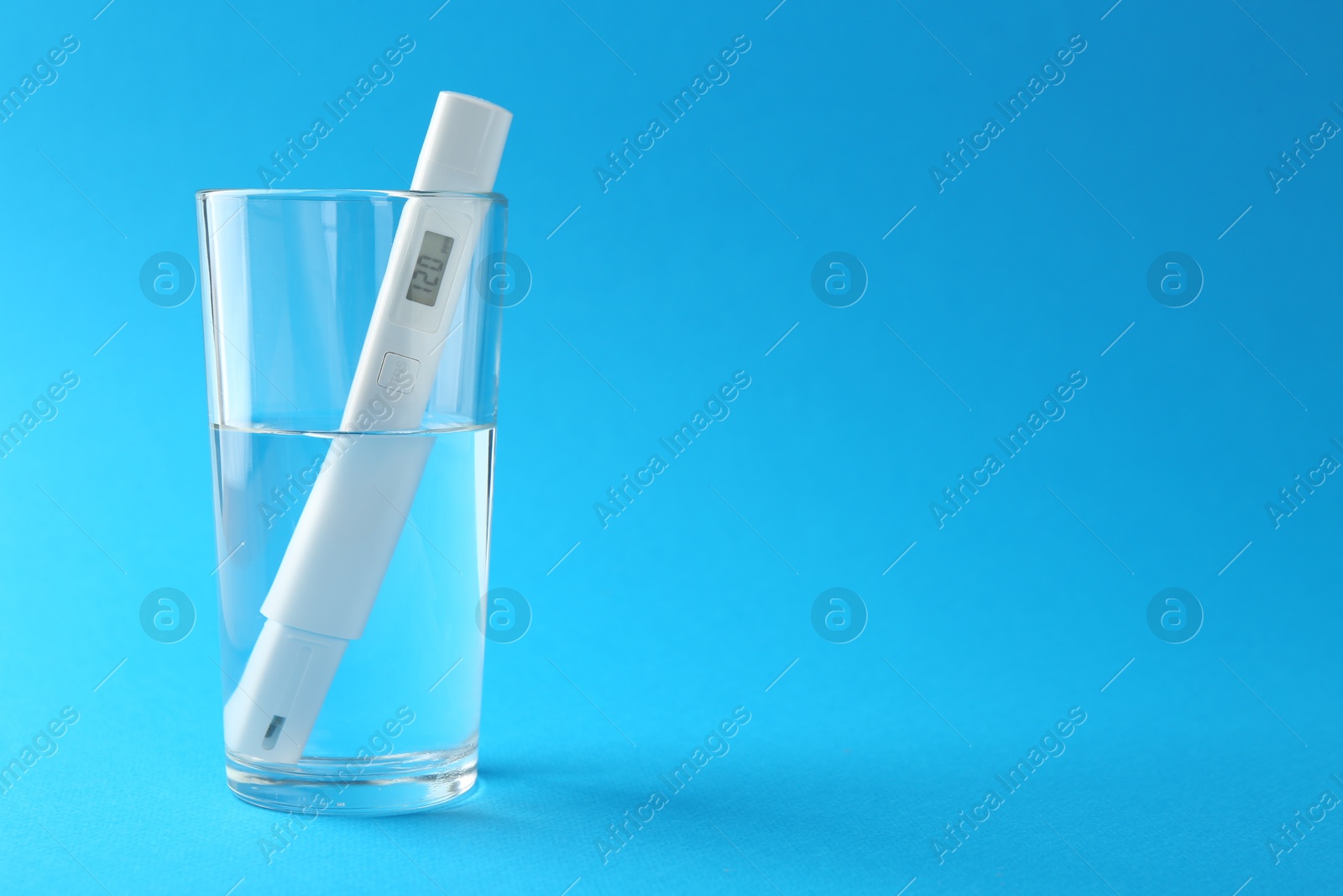 Nitrate tester in glass of water on light blue background, space for text Photo of Nitrate tester in glass of water on light blue background, space for text