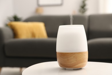 Photo of Modern aroma lamp on white table indoors. Space for text