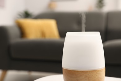 Photo of Modern aroma lamp on table indoors, closeup. Space for text