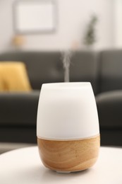 Photo of Modern aroma lamp on white table indoors