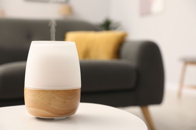 Photo of Modern aroma lamp on white table indoors. Space for text