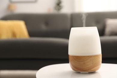Photo of Modern aroma lamp on white table indoors. Space for text