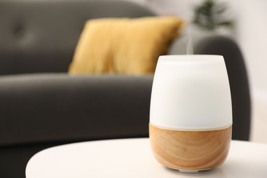 Photo of Modern aroma lamp on white table indoors. Space for text