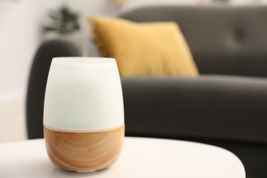 Photo of Modern aroma lamp on white table indoors. Space for text