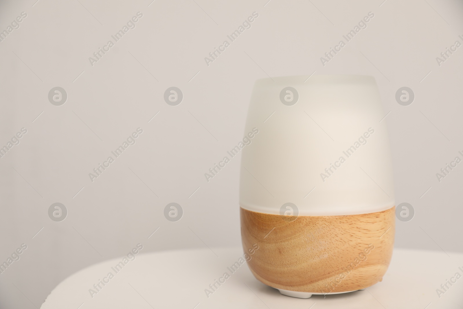 Modern aroma lamp on white table indoors. Space for text Photo of Modern aroma lamp on white table indoors. Space for text