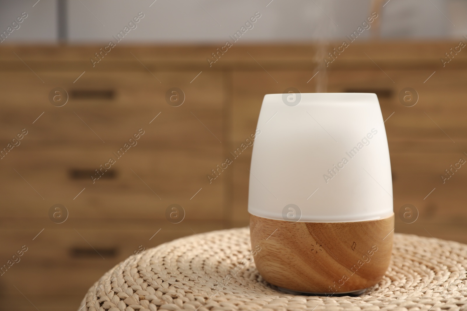 Modern aroma lamp on wicker surface indoors. Space for text Photo of Modern aroma lamp on wicker surface indoors. Space for text