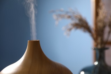 Photo of Modern aroma lamp against blurred background, closeup