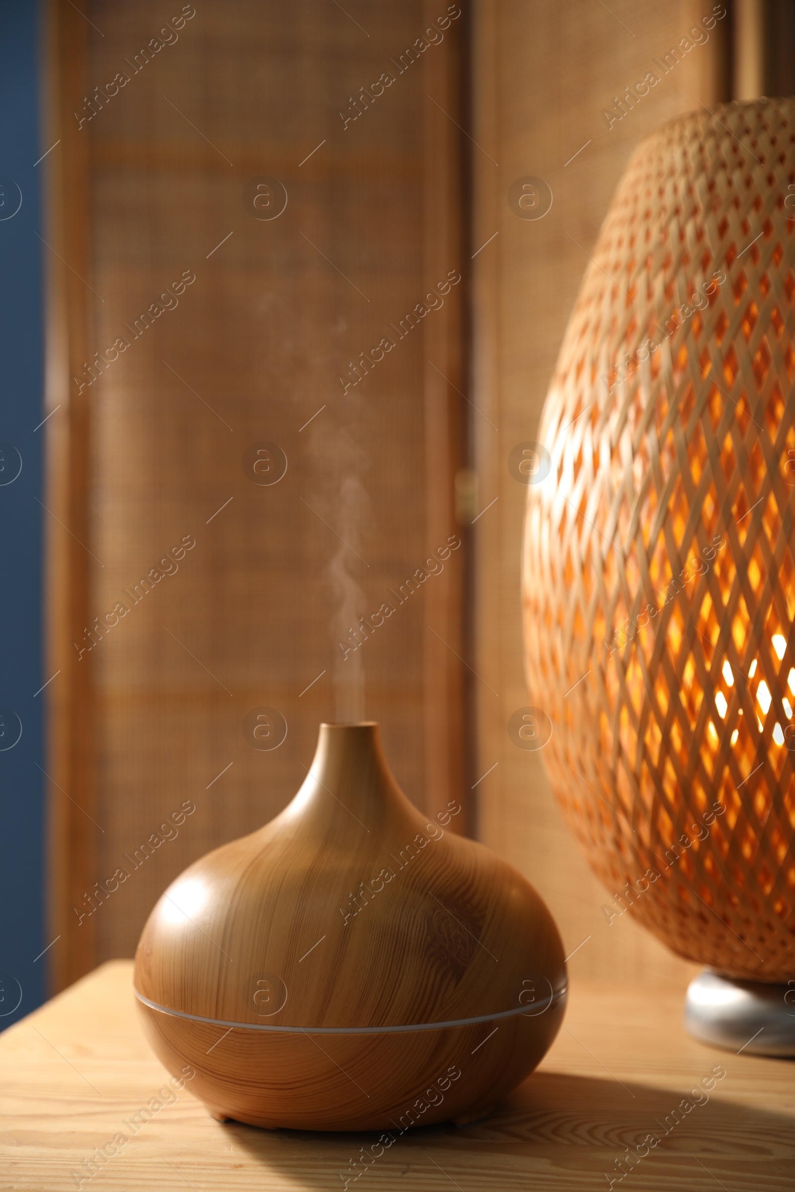 Modern aroma lamp on wooden table indoors Photo of Modern aroma lamp on wooden table indoors