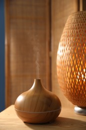 Photo of Modern aroma lamp on wooden table indoors