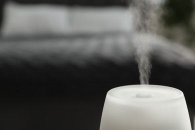 Photo of Modern aroma lamp against blurred background, closeup. Space for text