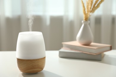 Photo of Modern aroma lamp on light table indoors