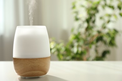 Photo of Modern aroma lamp on light table indoors. Space for text