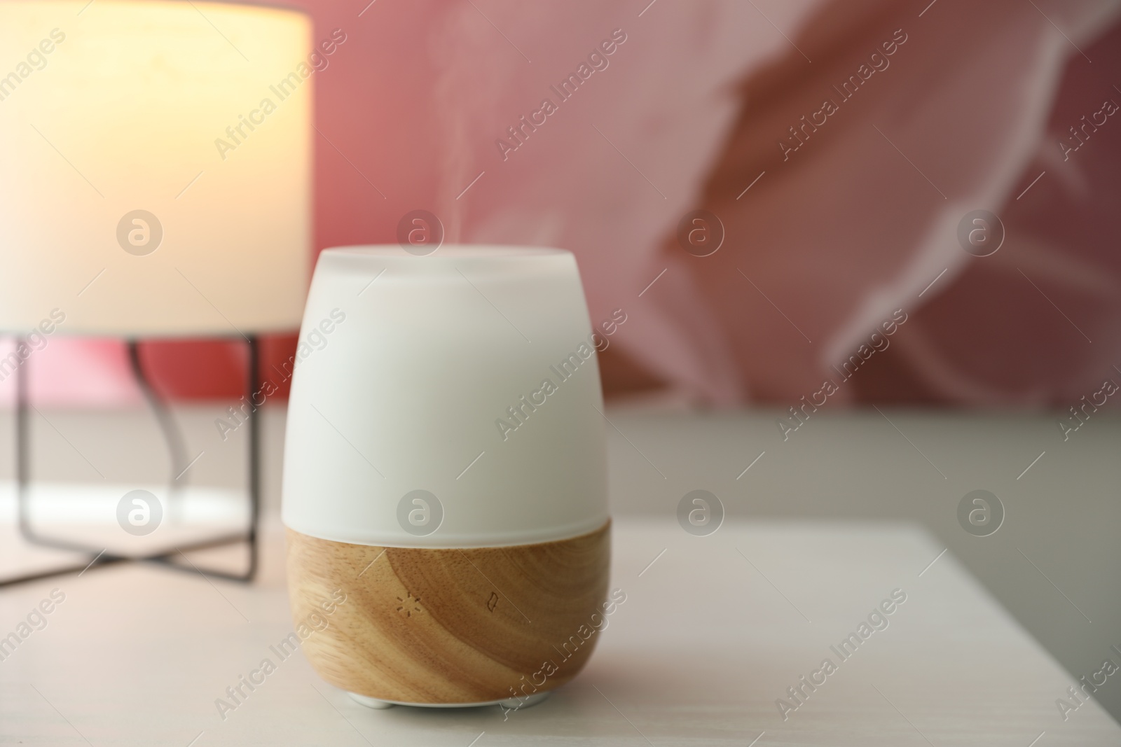 Modern aroma lamp on white wooden table, closeup Photo of Modern aroma lamp on white wooden table, closeup