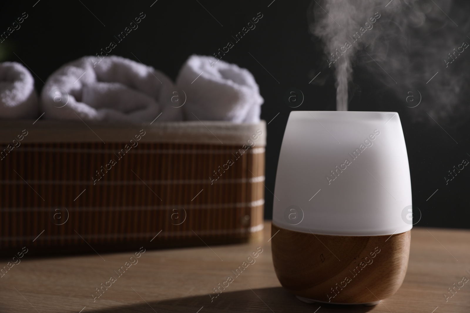 Modern aroma lamp on wooden table indoors Photo of Modern aroma lamp on wooden table indoors