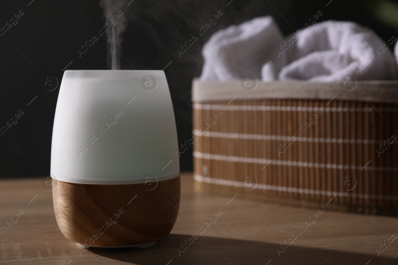 Modern aroma lamp on wooden table indoors Photo of Modern aroma lamp on wooden table indoors