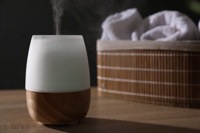 Photo of Modern aroma lamp on wooden table indoors