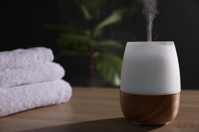 Photo of Modern aroma lamp on wooden table indoors