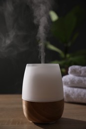 Photo of Modern aroma lamp on wooden table indoors