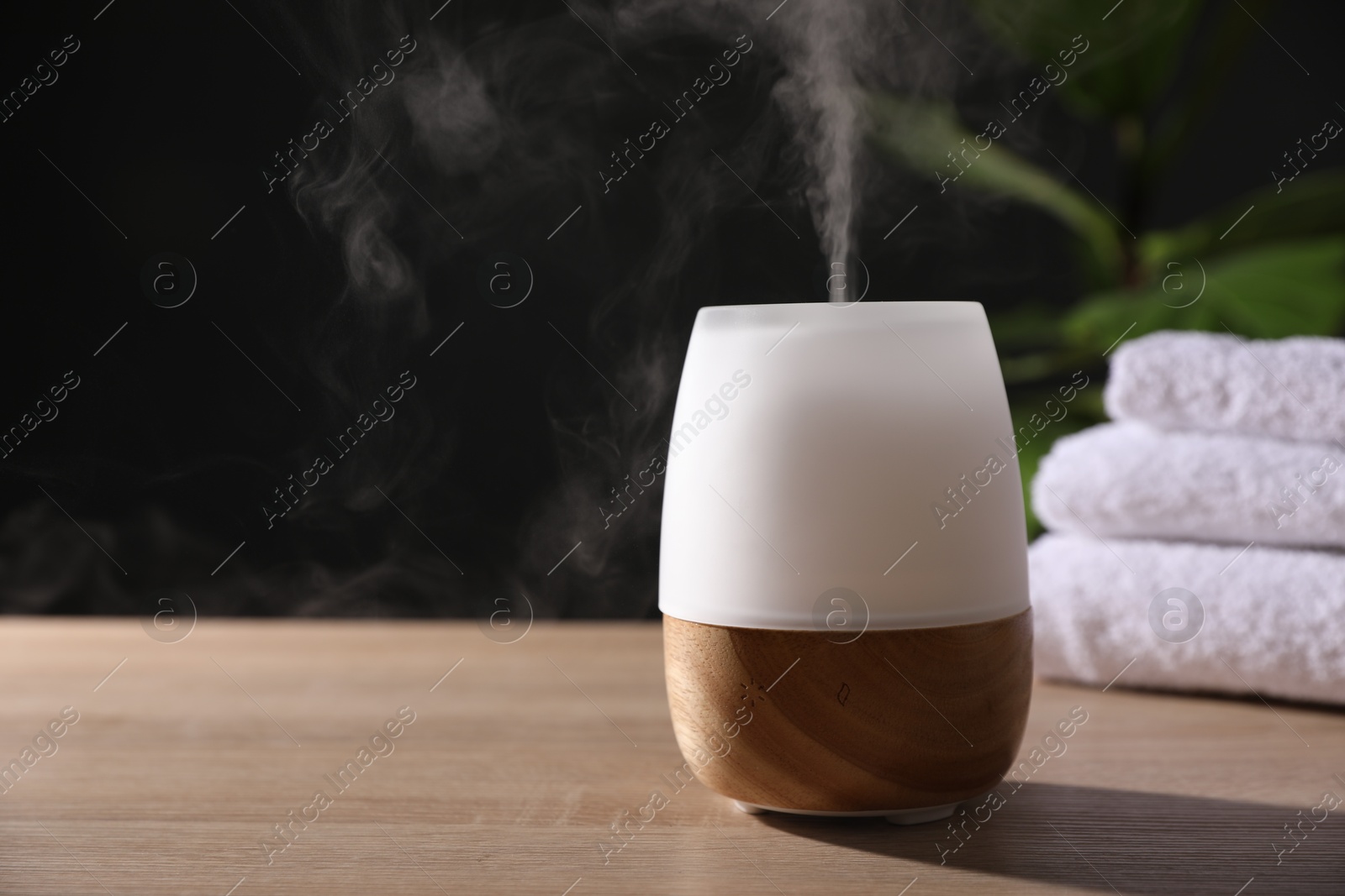 Modern aroma lamp on wooden table indoors. Space for text Photo of Modern aroma lamp on wooden table indoors. Space for text