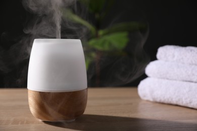 Photo of Modern aroma lamp on wooden table indoors