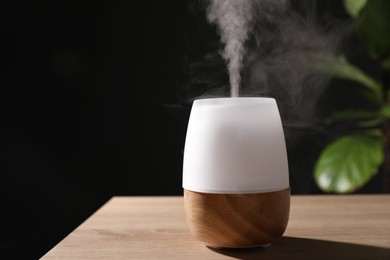 Photo of Modern aroma lamp on wooden table indoors