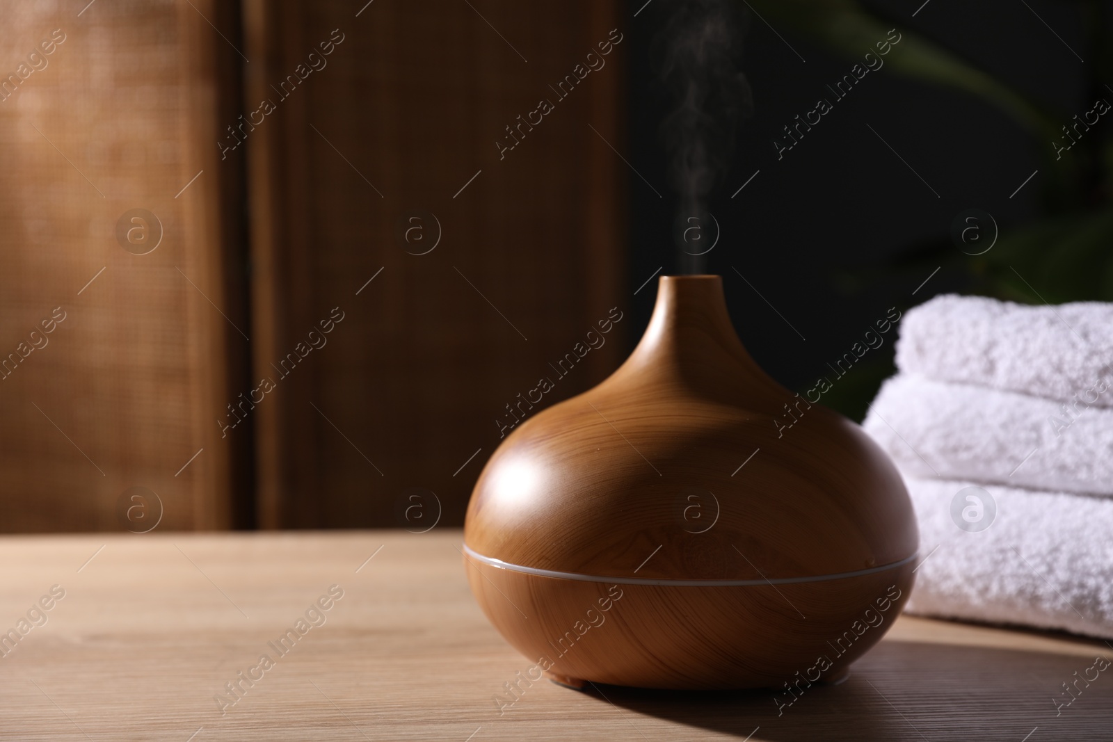 Modern aroma lamp on wooden table indoors, closeup. Space for text Photo of Modern aroma lamp on wooden table indoors, closeup. Space for text