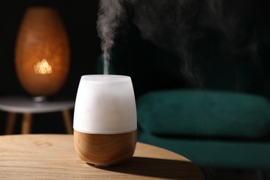 Photo of Modern aroma lamp on wooden table indoors