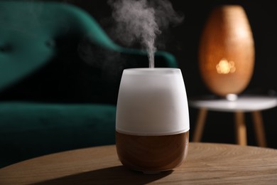 Photo of Modern aroma lamp on wooden table indoors