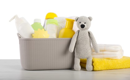 Photo of Different baby accessories and toy bear on table against white background