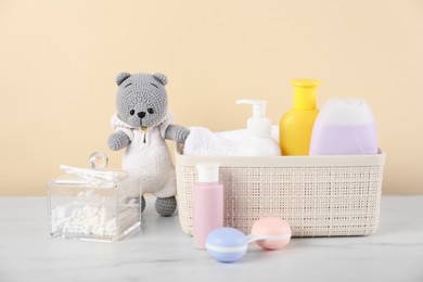 Photo of Different baby accessories and toy bear on table against beige background