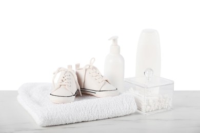 Photo of Different baby accessories and booties on table against white background