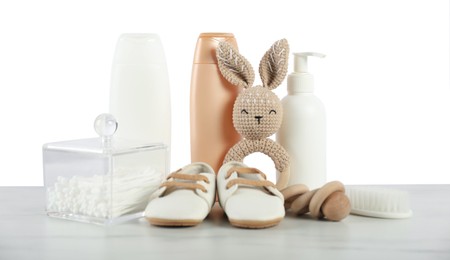 Photo of Different baby accessories and toys on table against white background