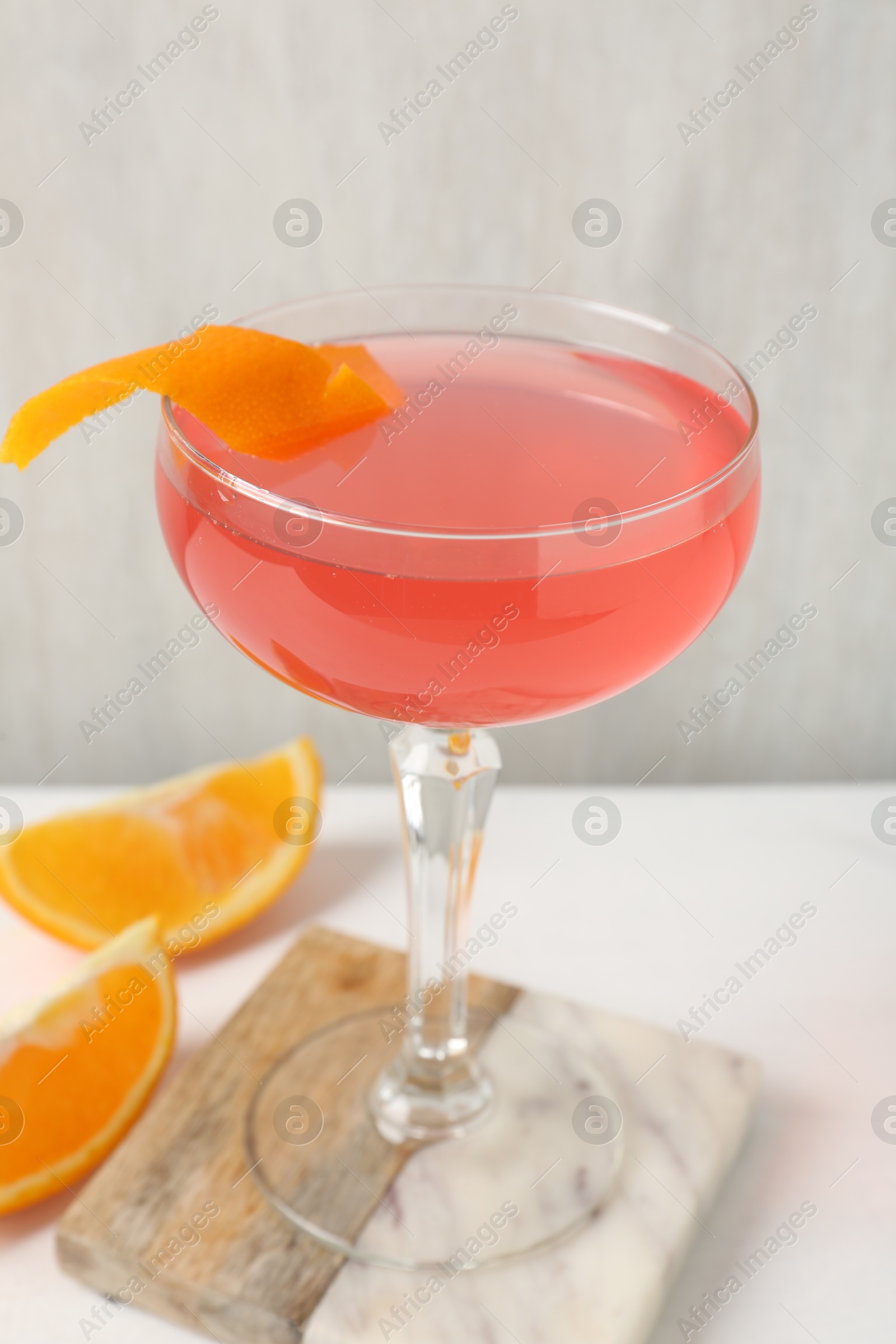 Martini cocktail with garnish and slices of orange on white table, closeup Photo of Martini cocktail with garnish and slices of orange on white table, closeup