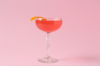 Photo of Martini cocktail with garnish on pink background