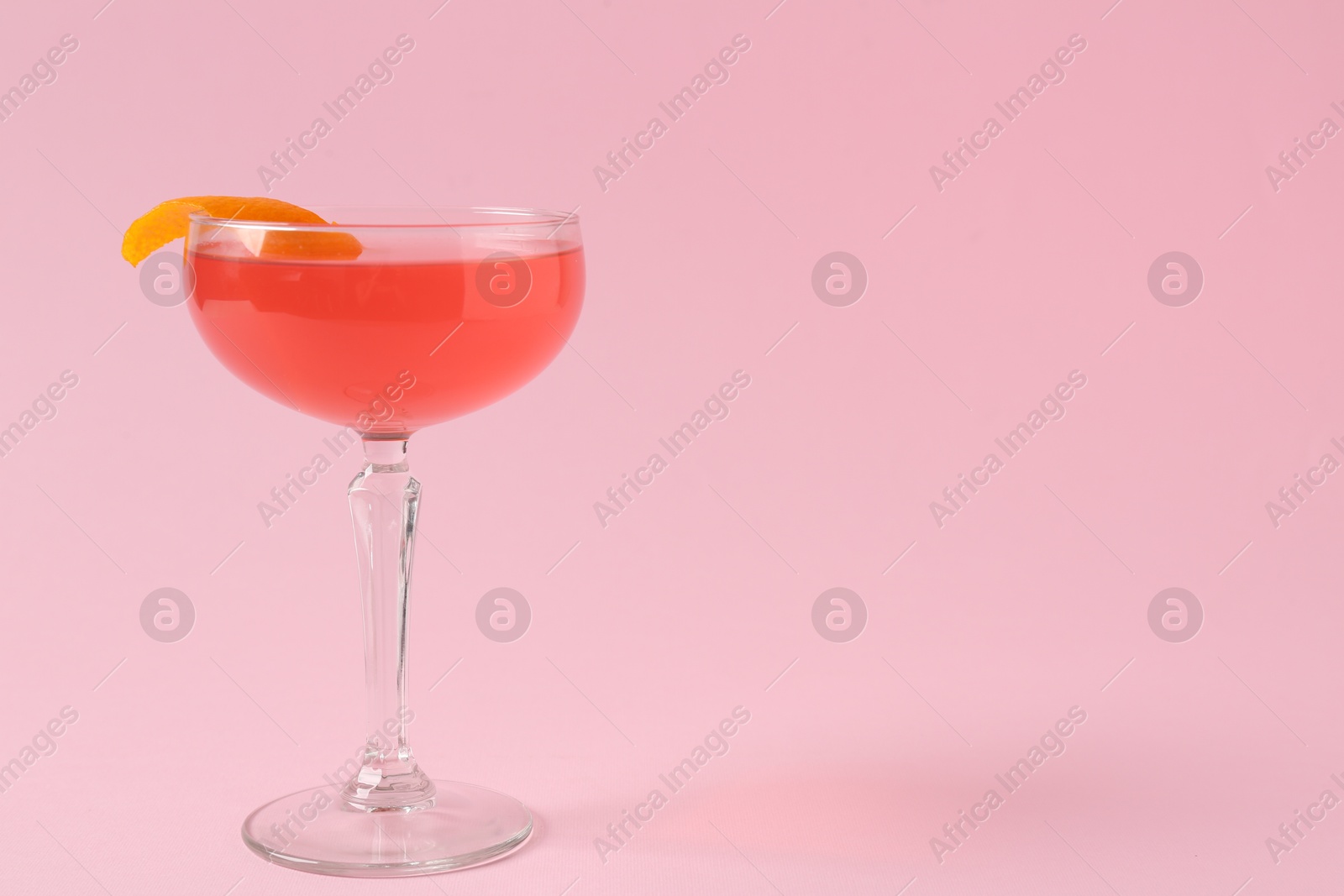 Martini cocktail with garnish on pink background, space for text Photo of Martini cocktail with garnish on pink background, space for text
