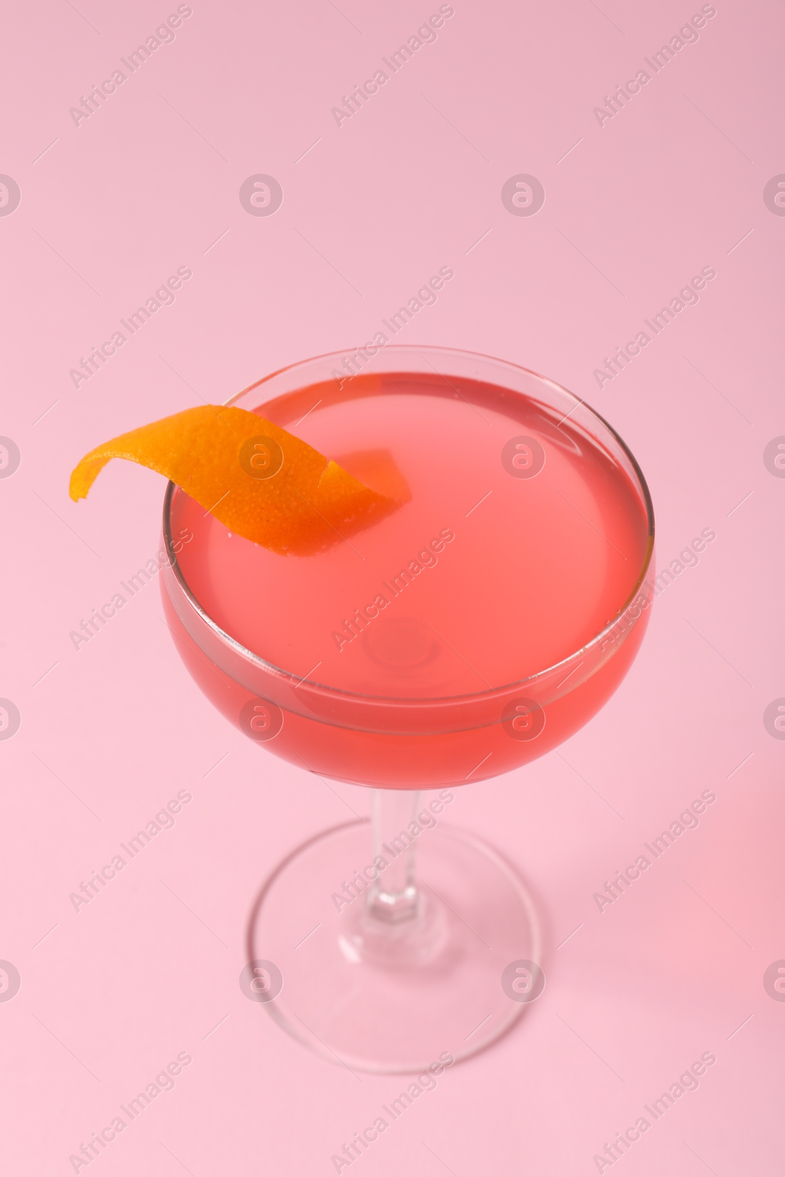 Martini cocktail with garnish on pink background, closeup Photo of Martini cocktail with garnish on pink background, closeup