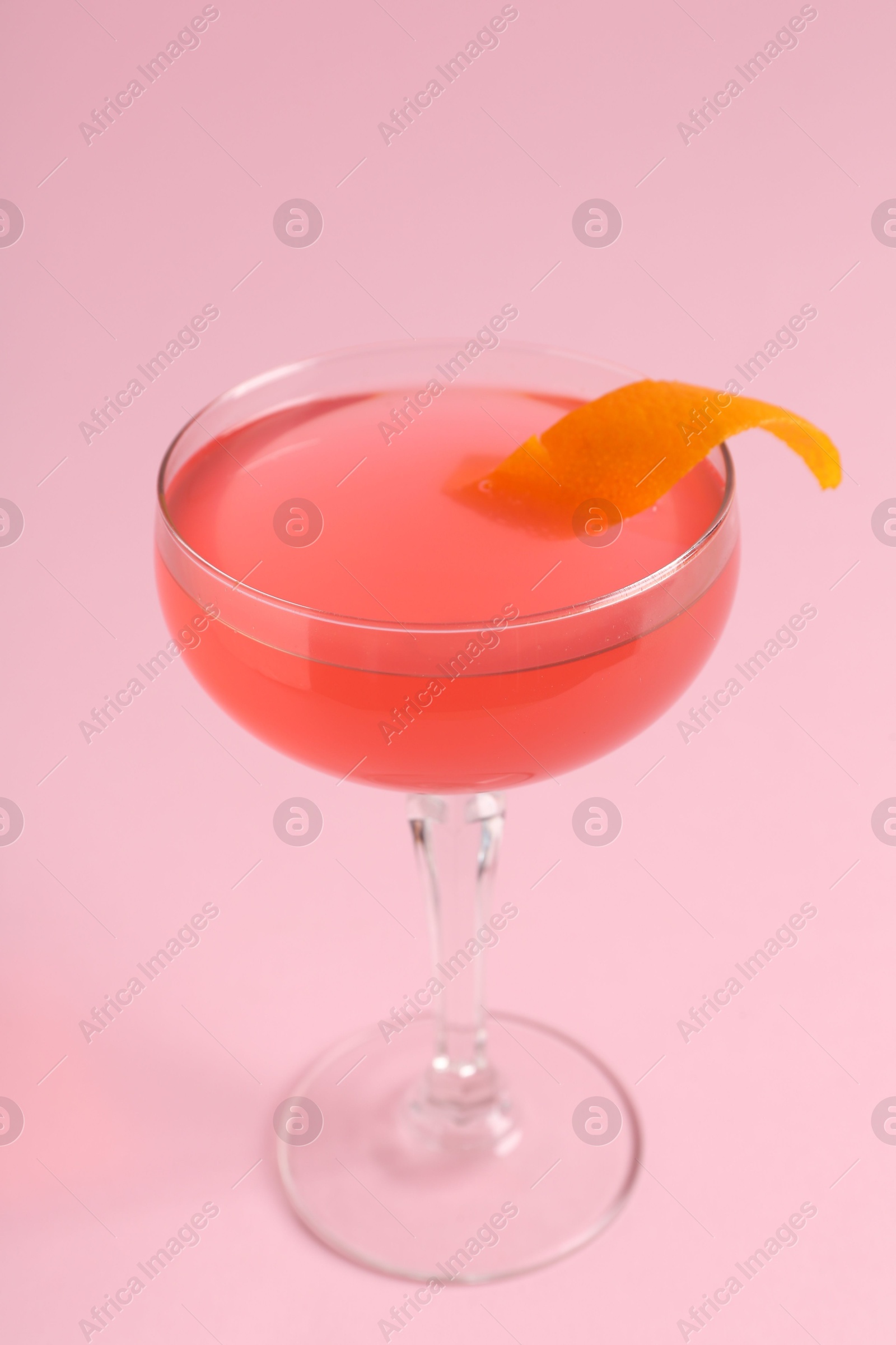Martini cocktail with garnish on pink background, closeup Photo of Martini cocktail with garnish on pink background, closeup