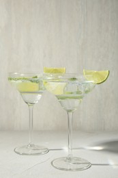 Photo of Martini cocktails with lime and mint on grey table