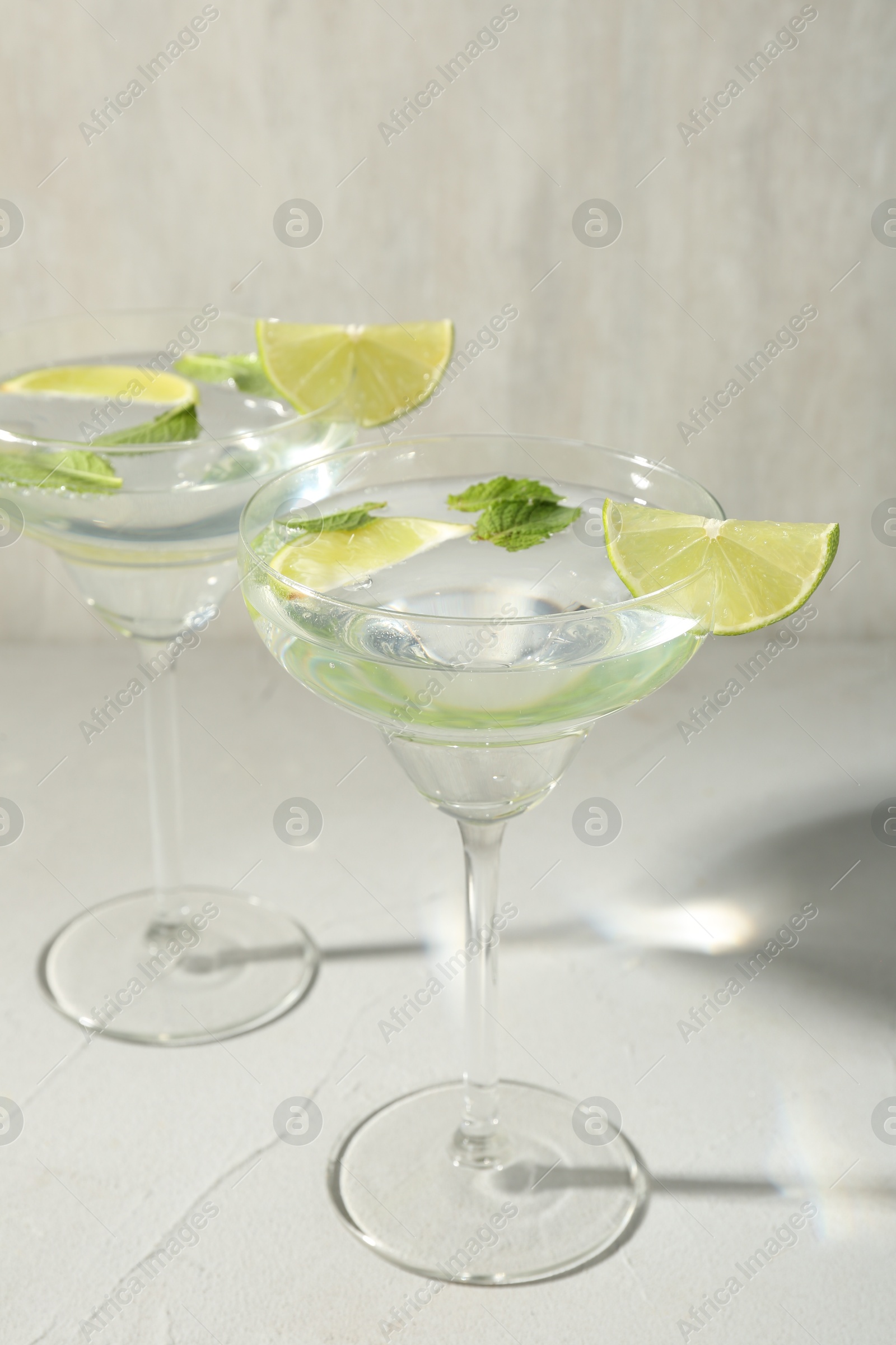 Martini cocktails with lime and mint on grey table, closeup Photo of Martini cocktails with lime and mint on grey table, closeup