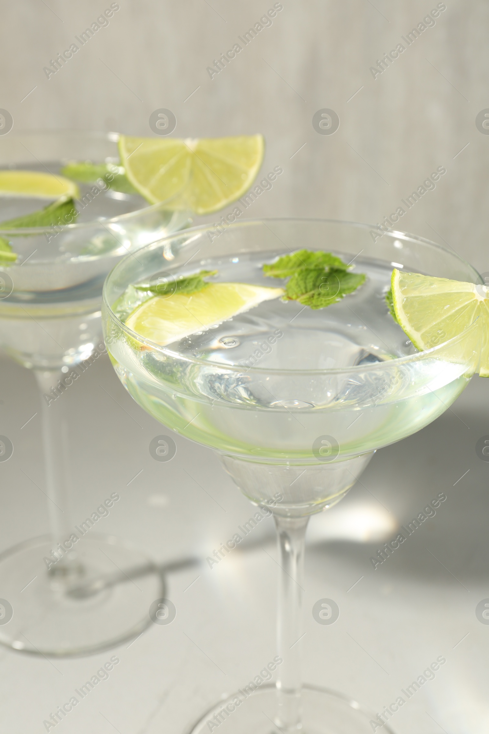 Martini cocktails with lime and mint on grey table, closeup Photo of Martini cocktails with lime and mint on grey table, closeup