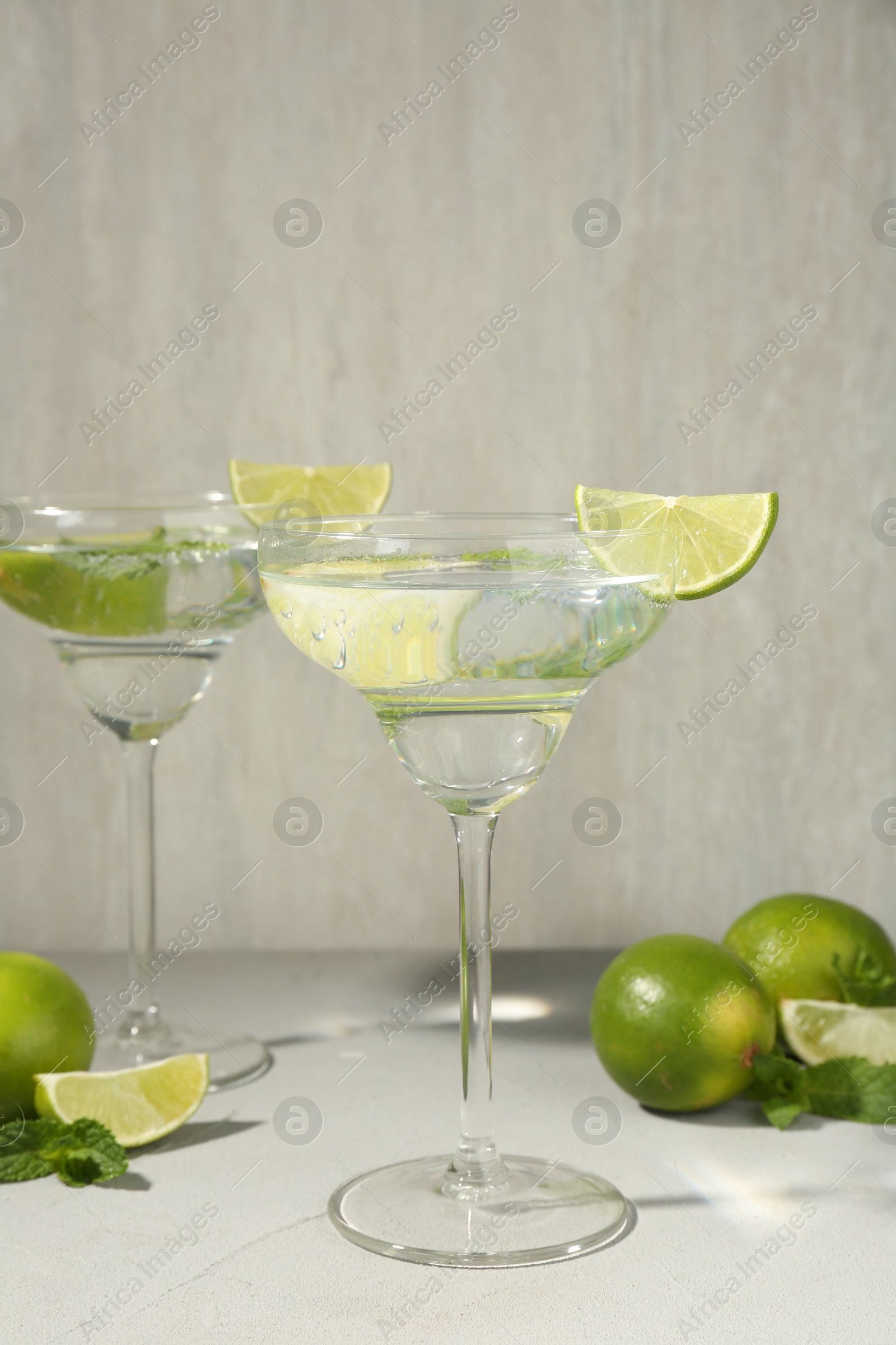 Martini cocktails with lime and mint on grey table, closeup Photo of Martini cocktails with lime and mint on grey table, closeup