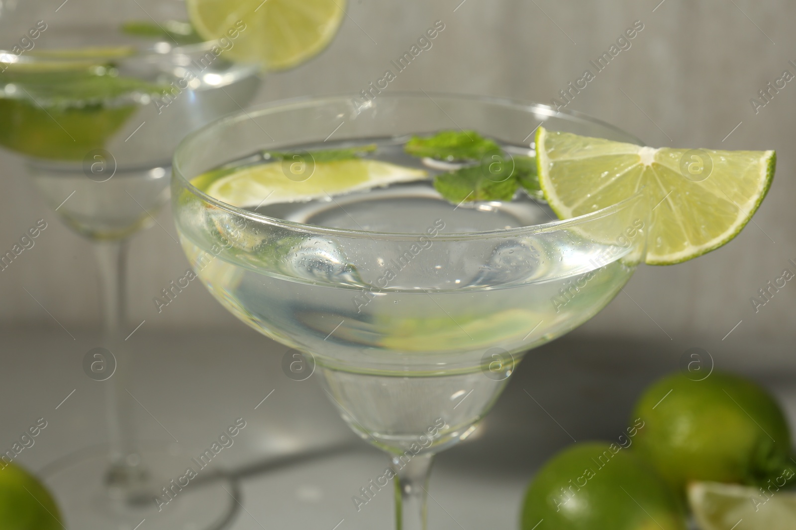 Martini cocktails with lime and mint on grey table, closeup Photo of Martini cocktails with lime and mint on grey table, closeup