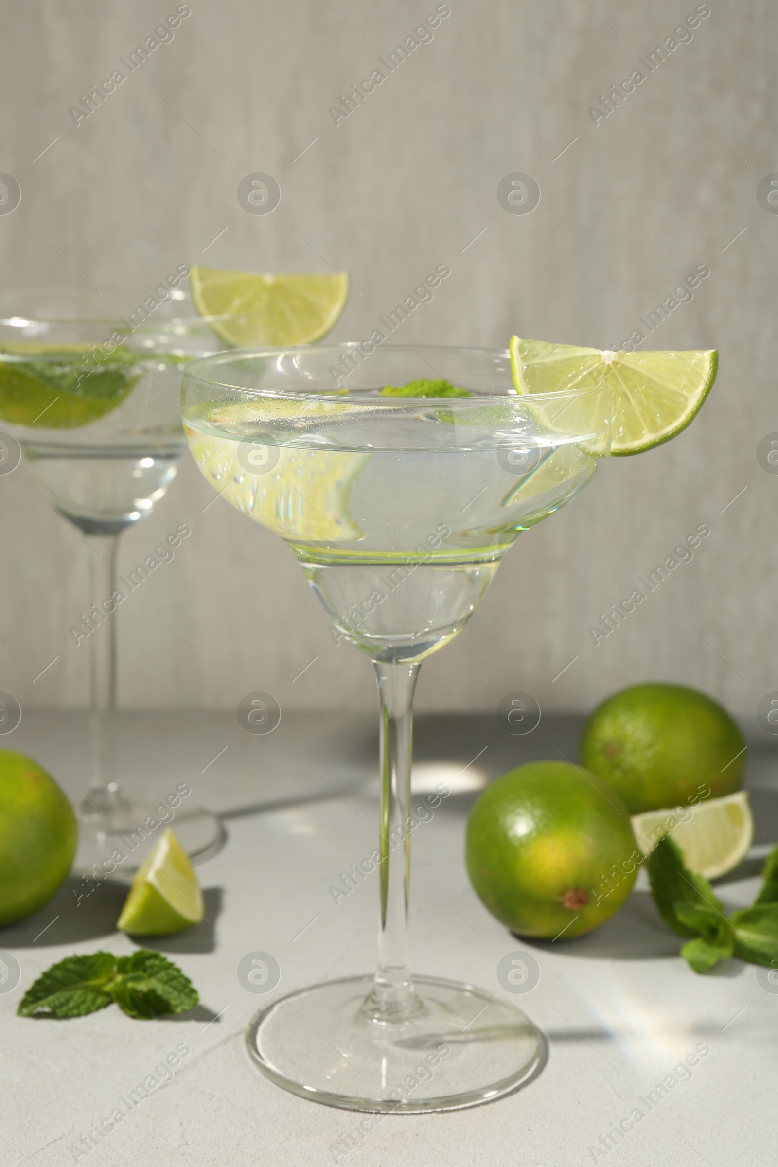 Martini cocktails with lime and mint on grey table, closeup Photo of Martini cocktails with lime and mint on grey table, closeup