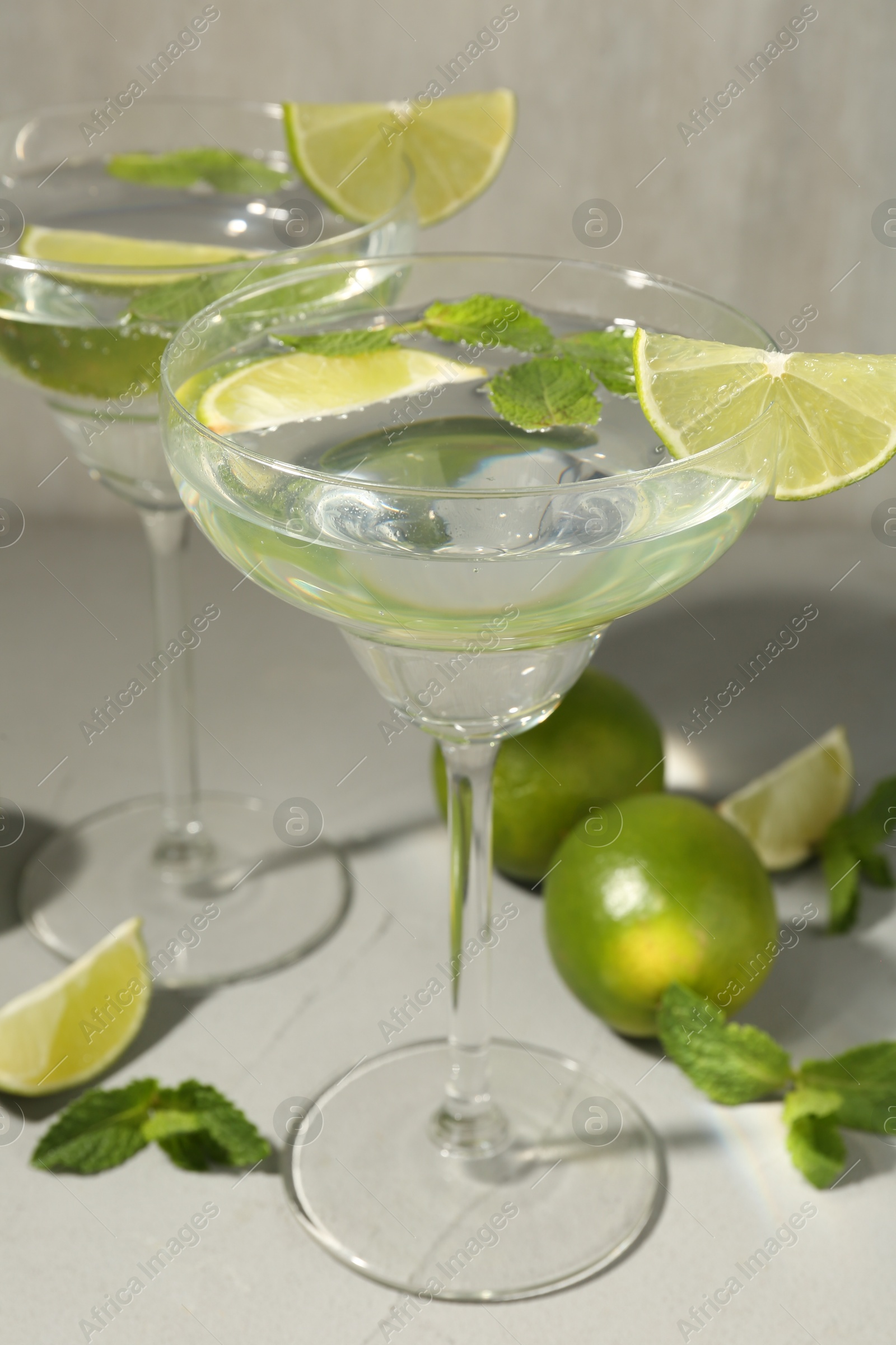 Martini cocktails with lime and mint on grey table, closeup Photo of Martini cocktails with lime and mint on grey table, closeup