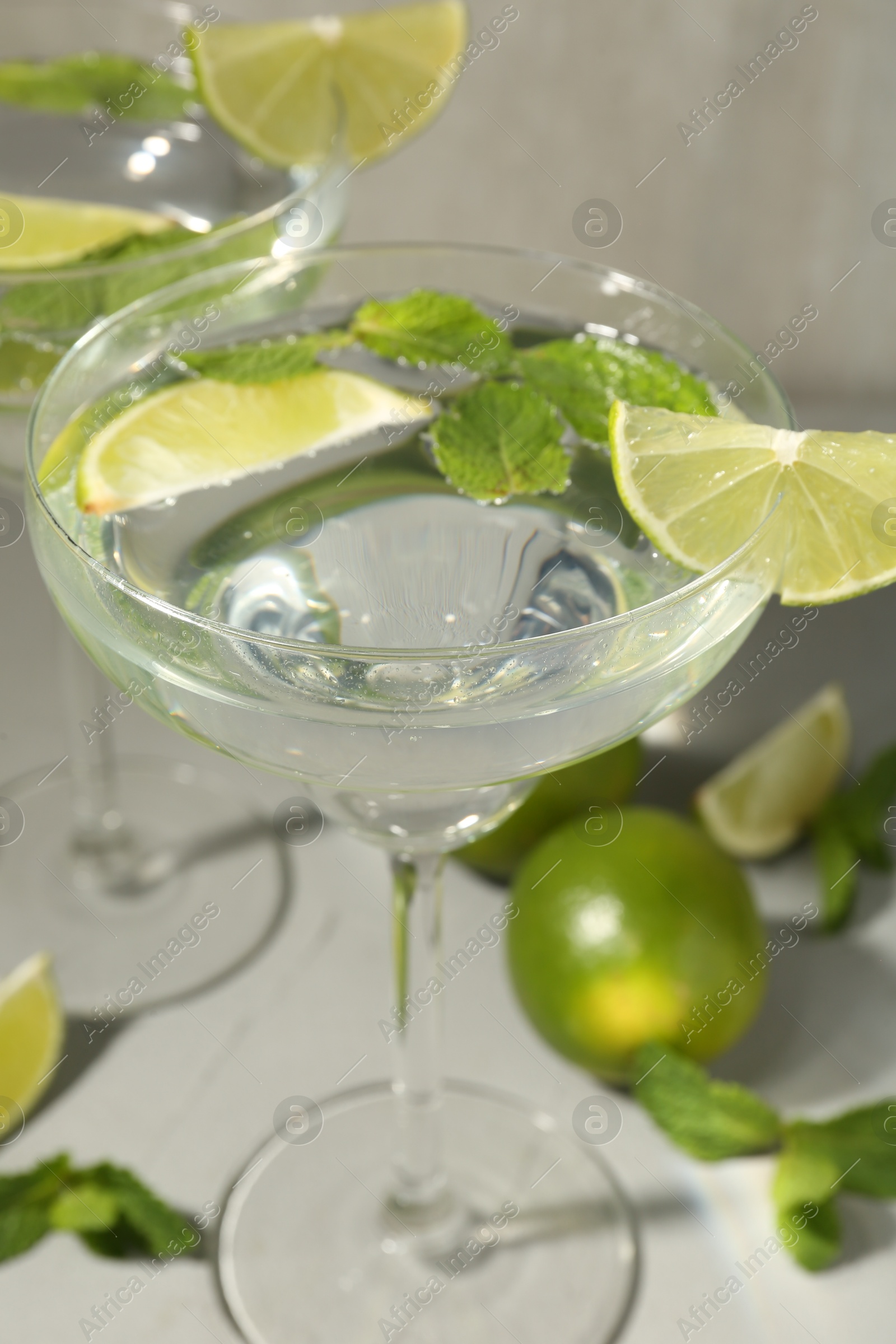 Martini cocktails with lime and mint on grey table, closeup Photo of Martini cocktails with lime and mint on grey table, closeup